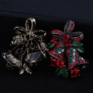 Macro detail of Christmas bell brooch featuring festive rhinestones and safety pin clasp