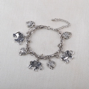 Detail of vintage silver bracelet with engraved elephant and heart-shaped metal charms