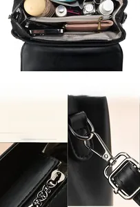 Detail view of the black leather bag interior compartments and silver hardware hooks