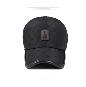 Detail of black quilted winter baseball cap with stitched diamond pattern and leather patch