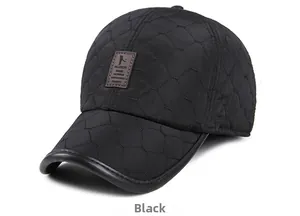 Detail of black winter baseball cap with quilted fabric and leather logo patch