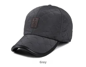 Detail of grey quilted baseball hat with diamond stitching and leather brand patch
