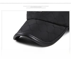 Detail of black quilted baseball cap brim with diamond stitching and leather piping edge
