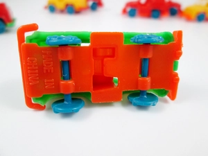 Macro shot of orange plastic chassis and blue wheels on mini toy jeep gift