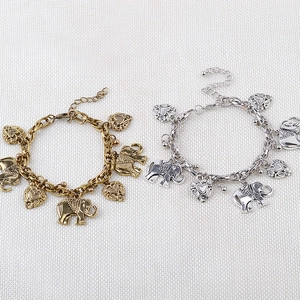 Detailed view of vintage elephant and heart charms on antique gold and silver bracelets