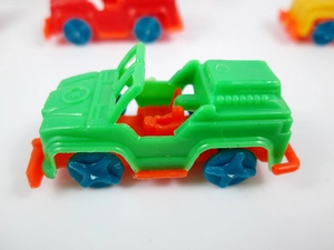 Macro view of green plastic mini jeep toy with orange chassis and star pattern