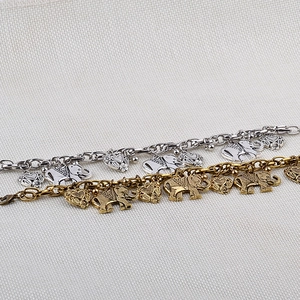 Detail of bohemian silver and bronze bracelets with elephant and heart pendants