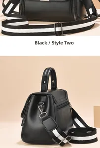 Detail view of small black crossbody bag with striped shoulder strap and back zipper pocket