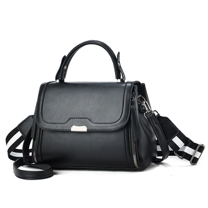 Minimalist black leather crossbody bag with striped shoulder strap and silver hardware