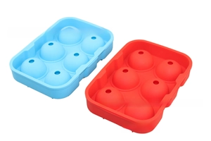 Detail view of 6-cavity spherical silicone ice molds in light blue and red for cocktails