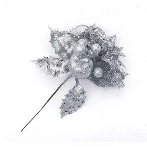 Close-up of silver glitter Christmas floral branch with holly leaves and berries decor