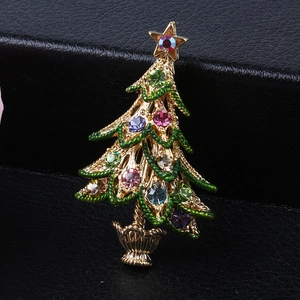 Close-up of a golden Christmas tree brooch with colorful rhinestones on black leather