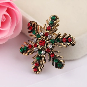 Macro detail of Christmas snowflake brooch with colorful crystals and antique gold finish