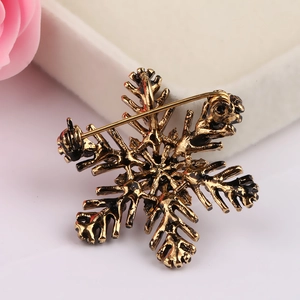 Detailed back view of snowflake brooch showing the secure vintage gold pin clasp