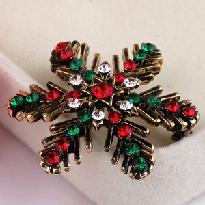 Macro shot of snowflake brooch with colorful crystals and vintage bronze finish detail