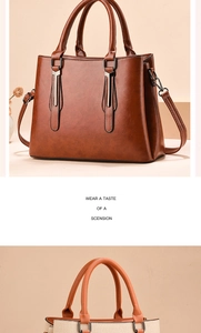 Detailed close-up showing the metallic buckles and side stitching of the leather handbag
