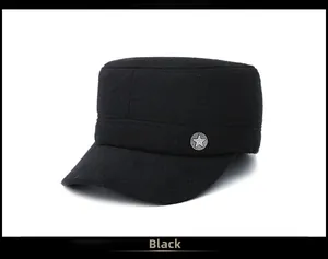 Détail d'une casquette militaire noire en laine avec badge métallique étoile