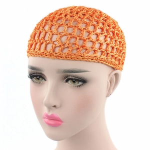 Detail of bright orange handmade crochet hair net cap with elastic mesh texture