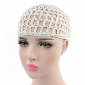 Detail of white handmade crochet hairnet with intricate mesh patterns on a model head