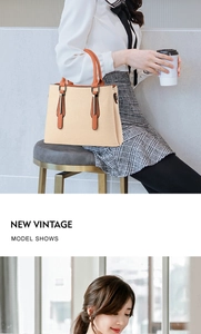 Detail of cream canvas handbag with tan leather handles and metal hardware accents