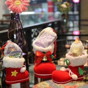 Three festive red Christmas gift boots with star, bell, and tree appliqués for holiday candy