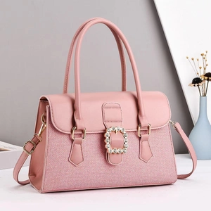 Detail van roze patchwork handtas met gouden strass gesp en afneembare schouderriem