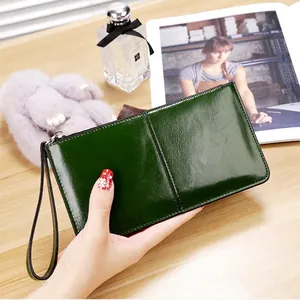 Detail of dark green oil wax leather long wallet with wristlet and metallic zipper
