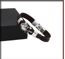 Close-up of a men's vintage woven leather bracelet with a silver skull charm on a box