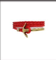 Detail of red braided rope nautical bracelet with golden anchor clasp on white background