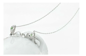 Detail view of silver necklace with Love script pendant and embedded white pearl charm