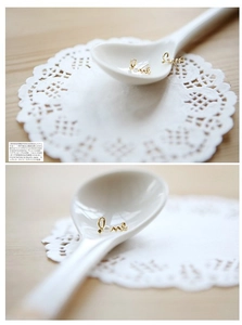 Detailed macro view of gold-tone Love script earring with a small pearl accent