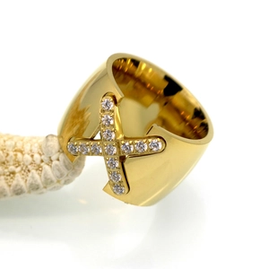 Close-up of golden wide ring with X-shaped white cubic zirconia inlay and mirror finish