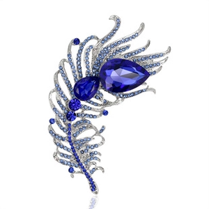 Macro detail of peacock feather brooch with blue crystals and rhinestones on silver base