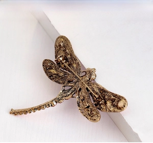 Detail view of the vintage metal dragonfly brooch back with a secure pin clasp mechanism