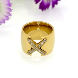 Macro detail of gold X-shaped cross ring with micro-paved cubic zirconia stones