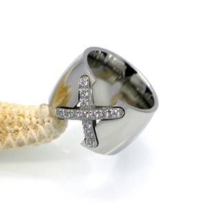 Macro shot of silver X-shaped cross ring with CNC-set cubic zirconia on starfish