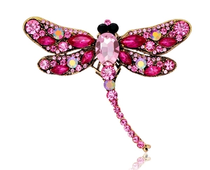 Detailed close-up of a pink dragonfly brooch with sparkling crystals and a gold base