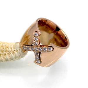 Macro shot of rose gold X-shape cross ring with micro-paved cubic zirconia crystals