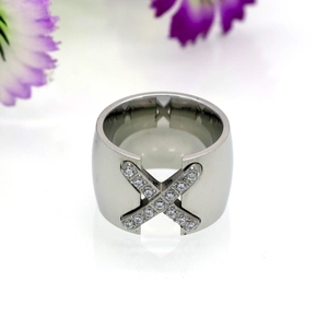 Detailed close-up of a wide titanium steel X-shaped ring with pave-set cubic zirconia stones
