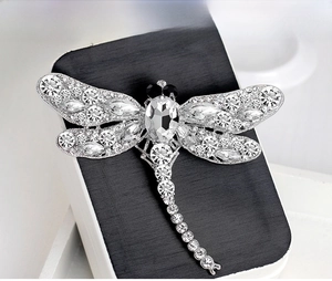 Detailed macro view of dragonfly brooch featuring clear rhinestones and silver alloy base