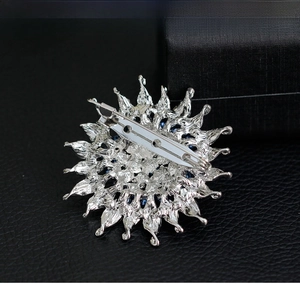 Makroansicht der Rückseite der silbernen Sonnenblumen-Brosche mit der Sicherheitsnadel