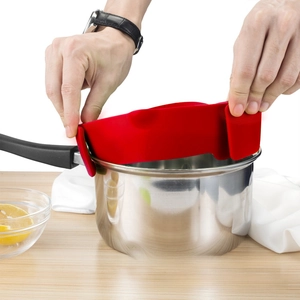 Detailed view of red silicone pot strainer with clips attached to a stainless steel pot