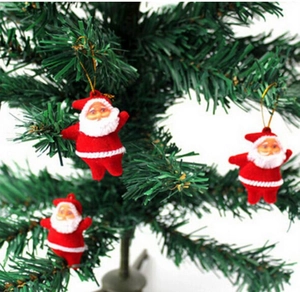 Three red flocked Santa Claus ornaments hanging on a Christmas tree branch