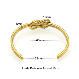 Polished gold stainless steel knot bangle with detailed measurements on white background