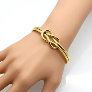 Minimalist polished gold knot bangle bracelet for women featuring an elegant double-line design