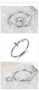 Macro detail of silver stainless steel H-shaped arrow bracelet and matching open ring set