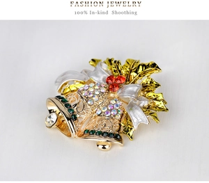 Detail of Christmas bell brooch featuring crystal rhinestones and golden holly leaves