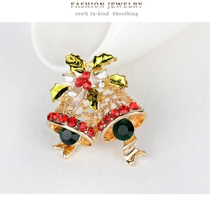 Detail of Christmas bell brooch with red and green rhinestones and a silver bow