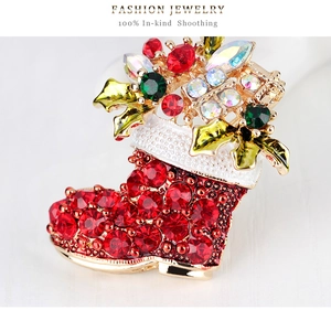 Macro shot of a Christmas boot brooch with red rhinestones and festive leaf details