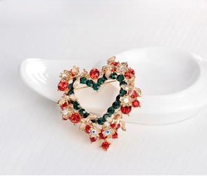 Detailed view of heart-shaped Christmas wreath brooch with red and green crystals